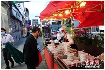 资料图：一家中餐厅在纽约法拉盛社区街道旁外卖菜肴。中新社记者廖攀摄

