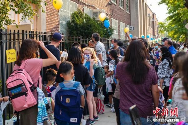 当地时间9月13日，美国纽约市公立学校开学，皇后区一所公立学校门前学生排队进入学校。开学后，纽约市公立学校不再提供线上课程。中新社记者 廖攀 摄