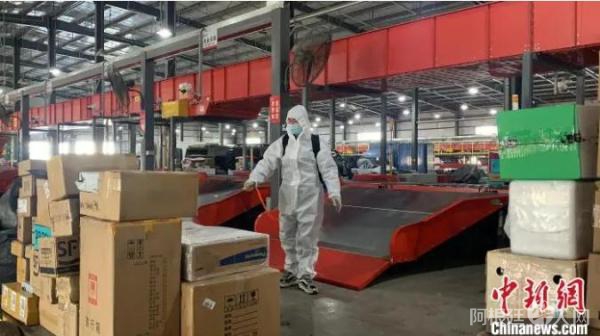图为工作人员“全副武装”为快递消杀。　奥蓝 摄
