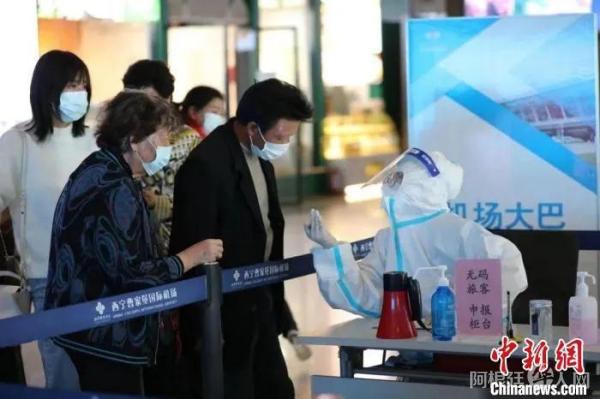 资料图：图为机场防疫工作人员为旅客测温检查。　李泽中 摄